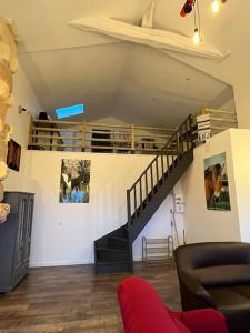 a living room with a staircase and a couch at Equizen33 maison zen et ressourçante in Saint-Mariens