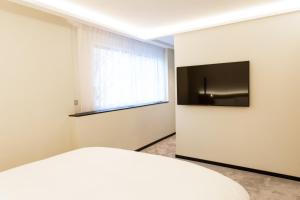 a bedroom with a bed and a television on a wall at Suite Montrachet 4 personnes vue cathédrale 1 Place de parking in Dijon