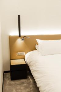 a bed with a nightstand next to a white bed at Suite Montrachet 4 personnes vue cathédrale 1 Place de parking in Dijon