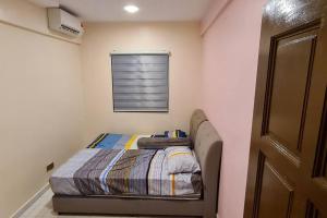 een kleine slaapkamer met een bed en een raam bij Holiday home in Port Dickson