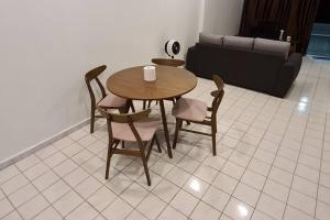 een tafel en stoelen in een woonkamer met een bank bij Holiday home in Port Dickson