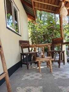 a porch with wooden chairs and a table at The Mellow Mango in Ko Lanta