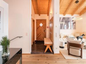 a living room with a wooden door and a couch at Premium chalet with sauna on a sunny slope in Wald im Pinzgau