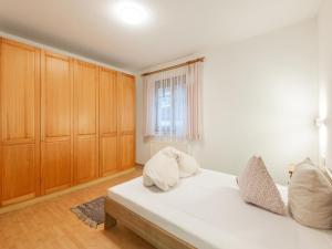 1 dormitorio con 1 cama con armarios de madera y ventana en Property in Kaltenbach en Kaltenbach