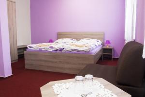 una camera da letto con un letto con pareti viola e due tavoli di Motel Pávov a Jihlava Altre 37 foto