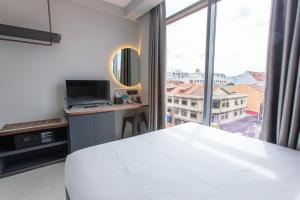 ein Schlafzimmer mit einem weißen Bett und einem großen Fenster in der Unterkunft ibis budget Singapore Gold in Singapur