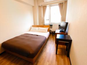 Postel nebo postele na pokoji v ubytování HOTEL LiVEMAX BUDGET Kawasaki Ekimae