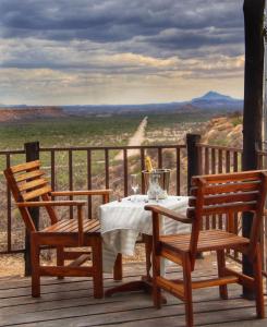 una mesa y sillas en una terraza con vistas en Ugab Terrace Lodge, en Fingerklippe 