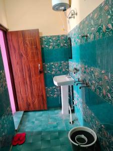 a bathroom with a sink and a wooden door at Pandava's Cafe & Stay in Chopta