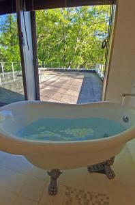 a bath tub with a view of a pool at Haramura - house / Vacation STAY 2211 in Hara