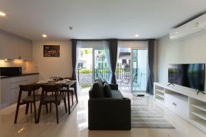 sala de estar con sofá, mesa y cocina en Mantra Beach condominium M116,M140, en Ban Phlong Sawai