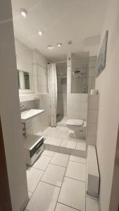 ein weißes Bad mit einem Waschbecken und einem WC in der Unterkunft MBZ Ferienwohnung TREVERE - 2 ZKB Balkon in Dillingen an der Saar