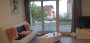 sala de estar con sofá y ventana grande en Ferienwohnung am Bodensee mit Seesicht und Wellness en Rorschacherberg