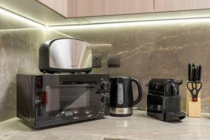 Příslušenství pro přípravu čaje a kávy v ubytování Spacious Pastel Studio by Suiteable Interiors