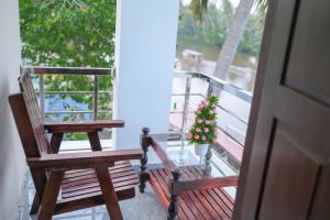 a porch with two wooden benches and a christmas tree at Janoos Homestay in Kumarakom