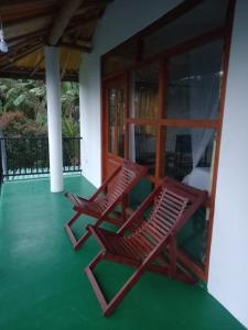 dos sillas sentadas en el porche delantero de una casa en Chamodya Home Stay en Ella