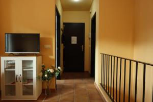a hallway with a black door and a tv on the wall at Casa La Buganvilla 1 Aracena in Aracena