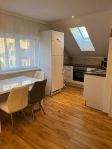 a kitchen with a table and chairs and a refrigerator at Ferienwohnung Alpina in Feldkirch