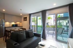sala de estar y cocina con sofá y mesa en Mantra Beach condominium M116,M140, en Ban Phlong Sawai