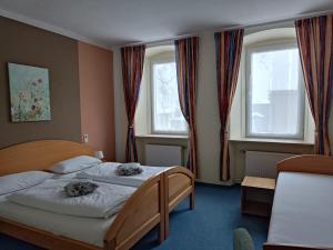 a bedroom with two beds and two windows at Garni Hotel Post in Weißenstadt +48 photos