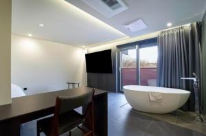 a large bathroom with a tub and a television at Hotel TARA in Seoul