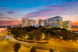 une ligne d'horizon avec de grands bâtiments la nuit dans l'établissement The Leela Bhartiya City Bengaluru, à Bangalore
