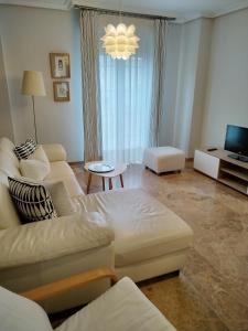 sala de estar con sofá y TV en Apartamento Puente Romano con Parking gratuito, en Córdoba