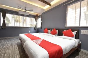 a bedroom with a large bed with red pillows at Hotel Ashirwad, Solapur in Solapur