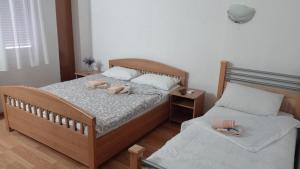 a bedroom with two beds with slippers on them at Hotel Konaciste Goc Trstenik in Trstenik