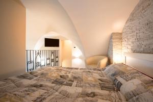 a bedroom with a bed and a stone wall at Sg Apartment Standard in Massafra