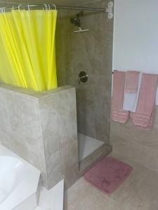 a shower with a yellow curtain in a bathroom at 4 Bedroom Home-Casino-State Farm Stadium only 2 Miles in Glendale