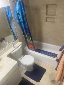 a bathroom with a toilet and a shower curtain at 4 Bedroom Home-Casino-State Farm Stadium only 2 Miles in Glendale