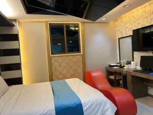 a hotel room with a bed and a desk and a television at Queen Drive-In Motel in Jeju