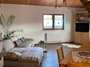 a living room with a couch and a table at Na zielonej łące... in Ruciane-Nida