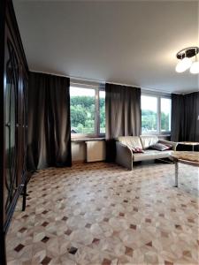 a living room with a couch and some windows at Apartament u Tomka Premium in Ustrzyki Dolne