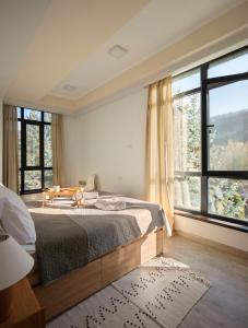1 dormitorio con cama y ventana grande en Cosy minimalistic apt. In Dilijan with great view, en Dilijan