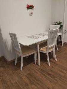 a white table with two chairs and a table with flowers at MosilorCentralBoutique in Bucharest