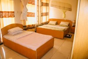 a bedroom with two beds in a room at Light House Hotel in Huye +5 photos