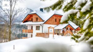 una casa nella neve con alberi innevati di R&R Residenzen Aparthotel a Mitterbach