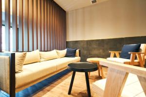 a living room with a couch and a stool at Rakuten STAY Kokura Station Family Room in Kitakyushu