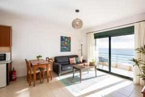 a living room with a couch and a table at Portela Suites Kastri in Keratokampos