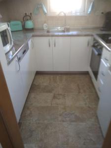 uma cozinha com armários brancos e um lavatório em Villa Brabant em Stolac