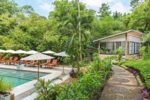 Thalassa Dive & Wellbeing Resort Manado في مانادو: منزل به مسبح ومنتجع