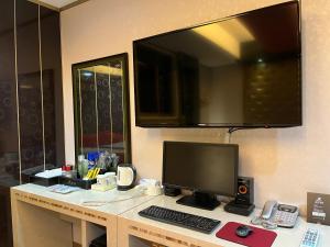 a desk with a computer and a monitor on it at Queen Drive-In Motel in Jeju