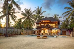 een huis aan het strand met palmbomen bij Villa Terra in Gili Trawangan