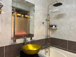 a bathroom with a yellow sink and a tub at Queen Drive-In Motel in Jeju