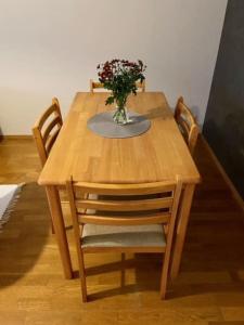 a wooden table with a vase of flowers on it at Huoneisto Jalkarannassa in Lahti