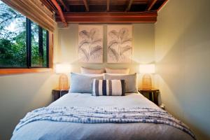JagganTreetops Sanctuary - Luxury Treehouse pole home的一间卧室，有一张大床，配有两盏灯