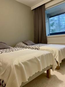 1 Schlafzimmer mit 2 Betten und einem Fenster in der Unterkunft Huoneisto Jalkarannassa in Lahti