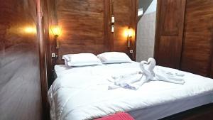 una camera da letto con letto, lenzuola e cuscini bianchi di Wisma Andany a Jepara